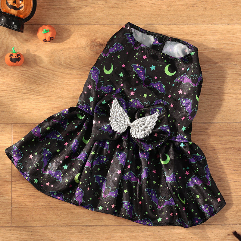 Black dress with Halloween-themed pattern and angel wings on a wooden surface