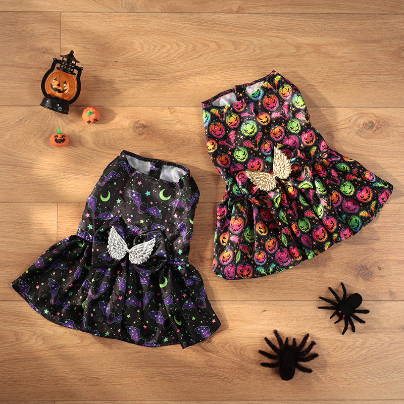 Two dog's dresses with Halloween-themed patterns on a wooden surface.
