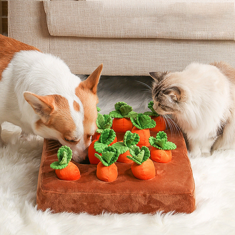 Two cats playing with a carrot-shaped pet toy on a brown cushion.