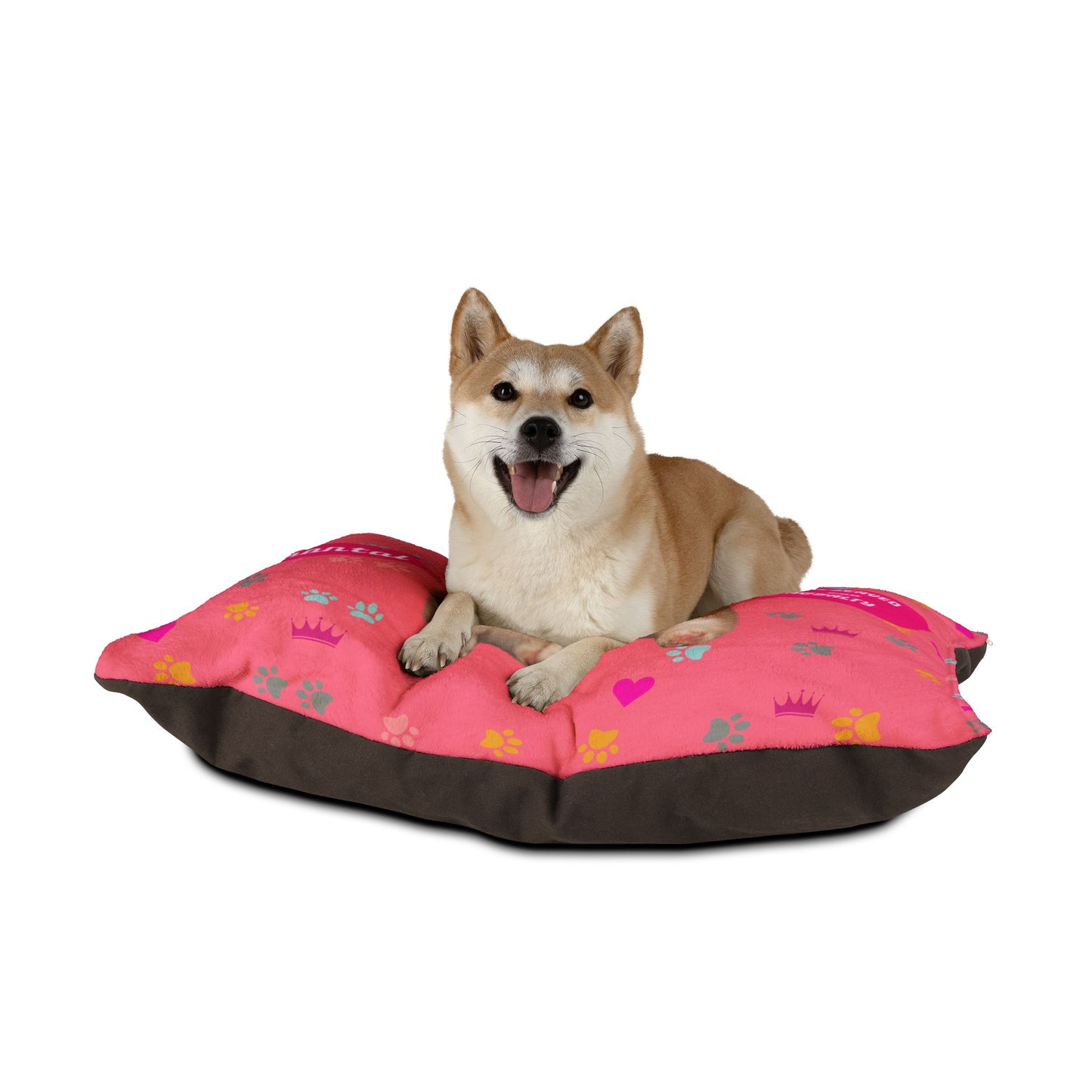 Dog lying on a pink and brown pet bed with paw prints and hearts on a white background