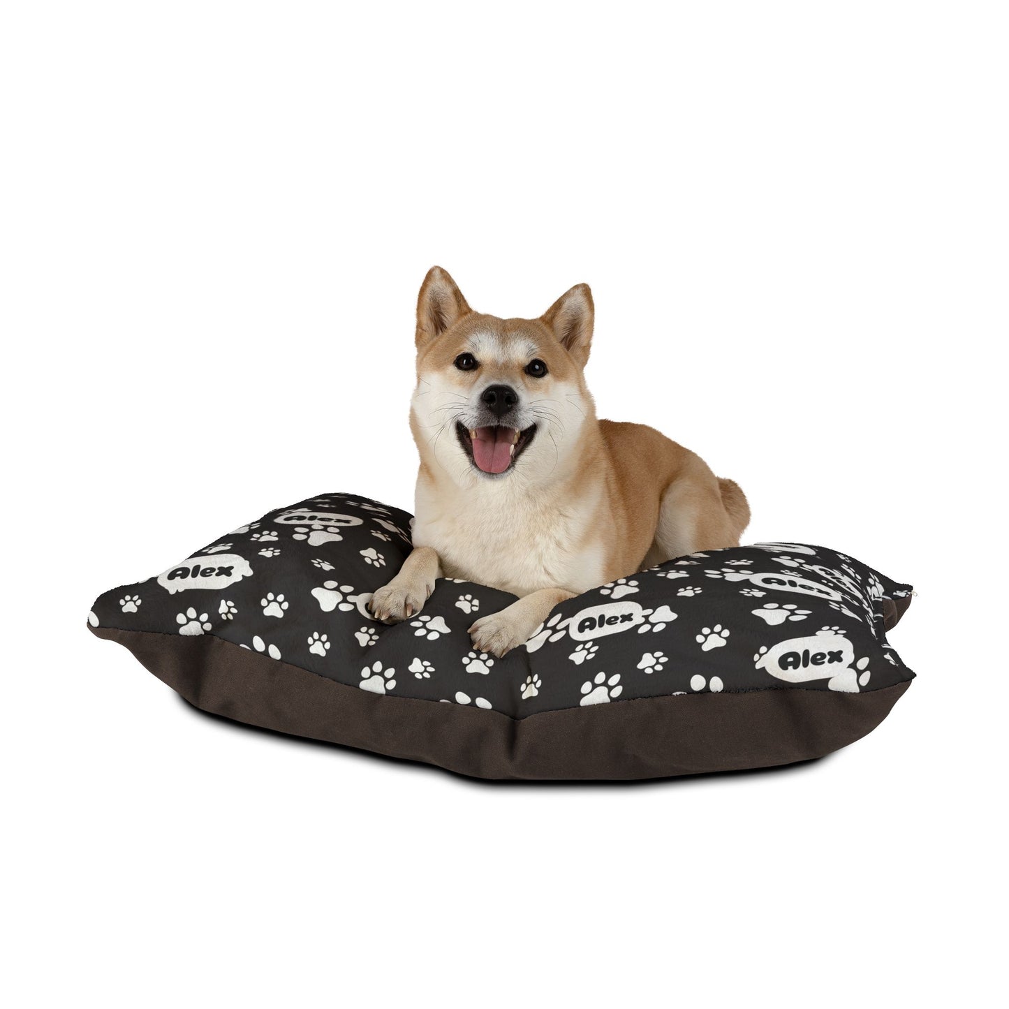 Dog sitting on a black pet bed with white paw prints and 'Alex' branding.