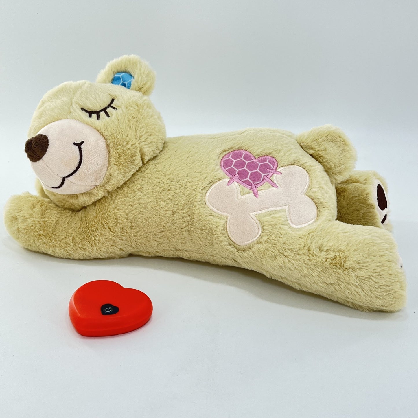 Plush toy bear with a heart-shaped patch on a white background