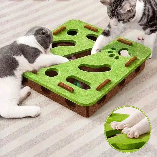 Two cats playing with a green and brown cat toy on a carpeted floor.