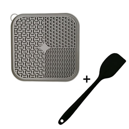 Gray Dog Licking Mat Slow Feeder with wavy pattern and honeycomb design, plus a black spatula on a white background.