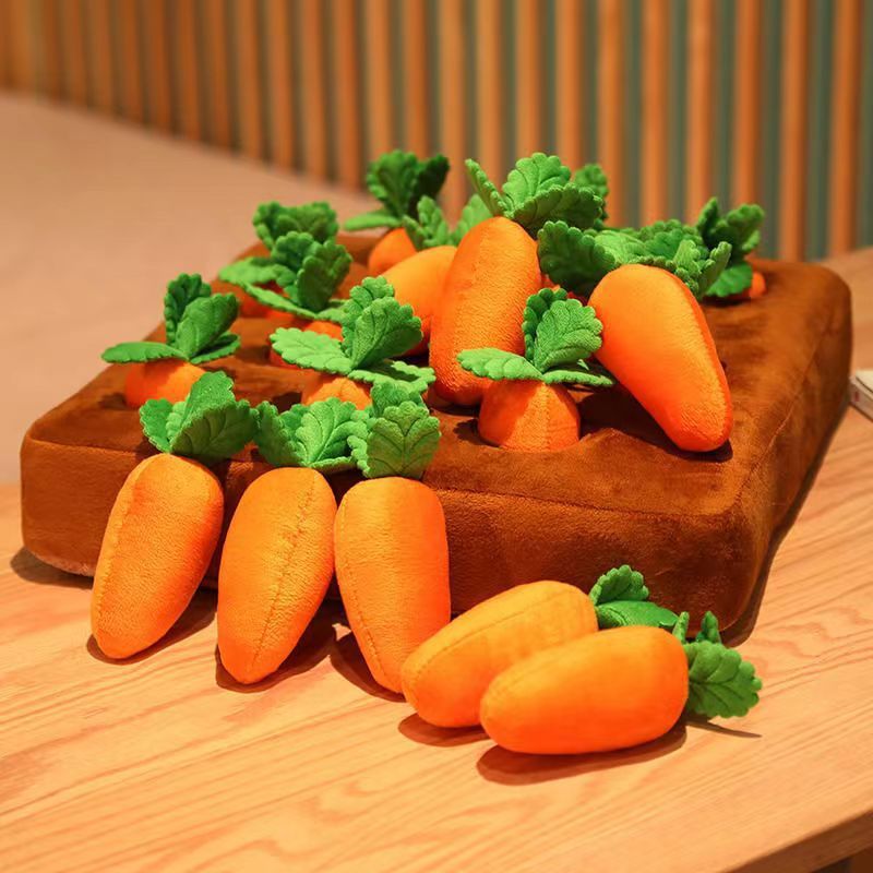 Plush carrots with green leaves on a wooden cutting board