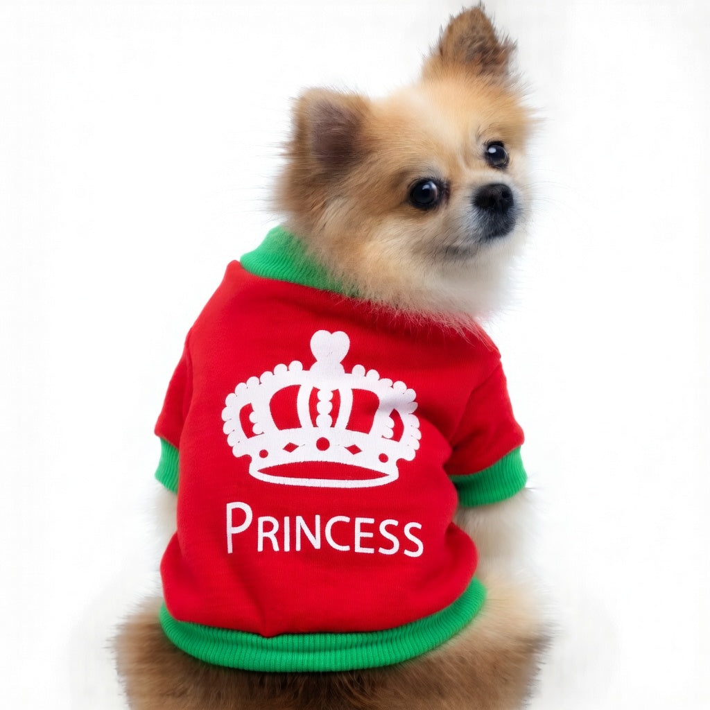 Small dog wearing a red Festive Pet Christmas Outfit 'Princess' outfit with a green trim on a white background