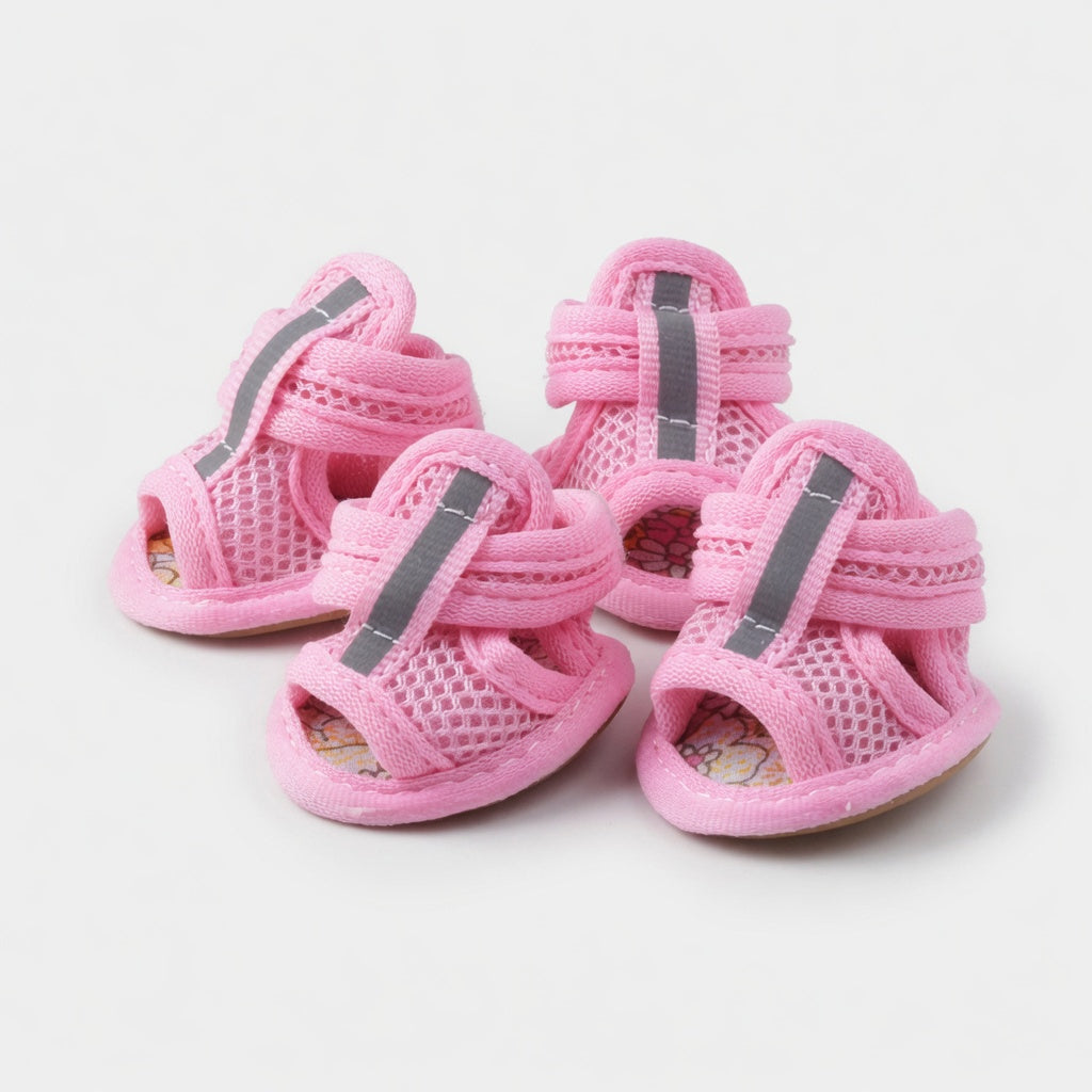 Four pink dog sandals in a white background