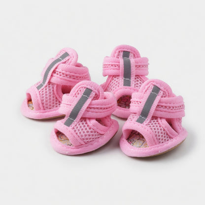 Four pink dog sandals in a white background