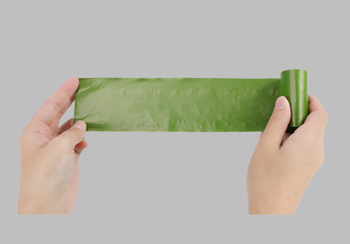 A person holding a stretched biodegradable pet garbage bag roll, showcasing its length and durability for convenient use