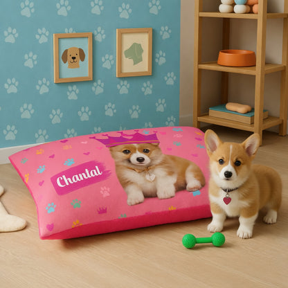 Dog standing next to a pink personalized pet bed with a puppy picture and 'Chantal' text, in a room with paw print wallpaper and a wooden shelf.