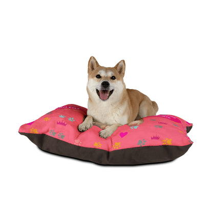 Dog lying on a pink and brown pet bed with paw prints and hearts on a white background