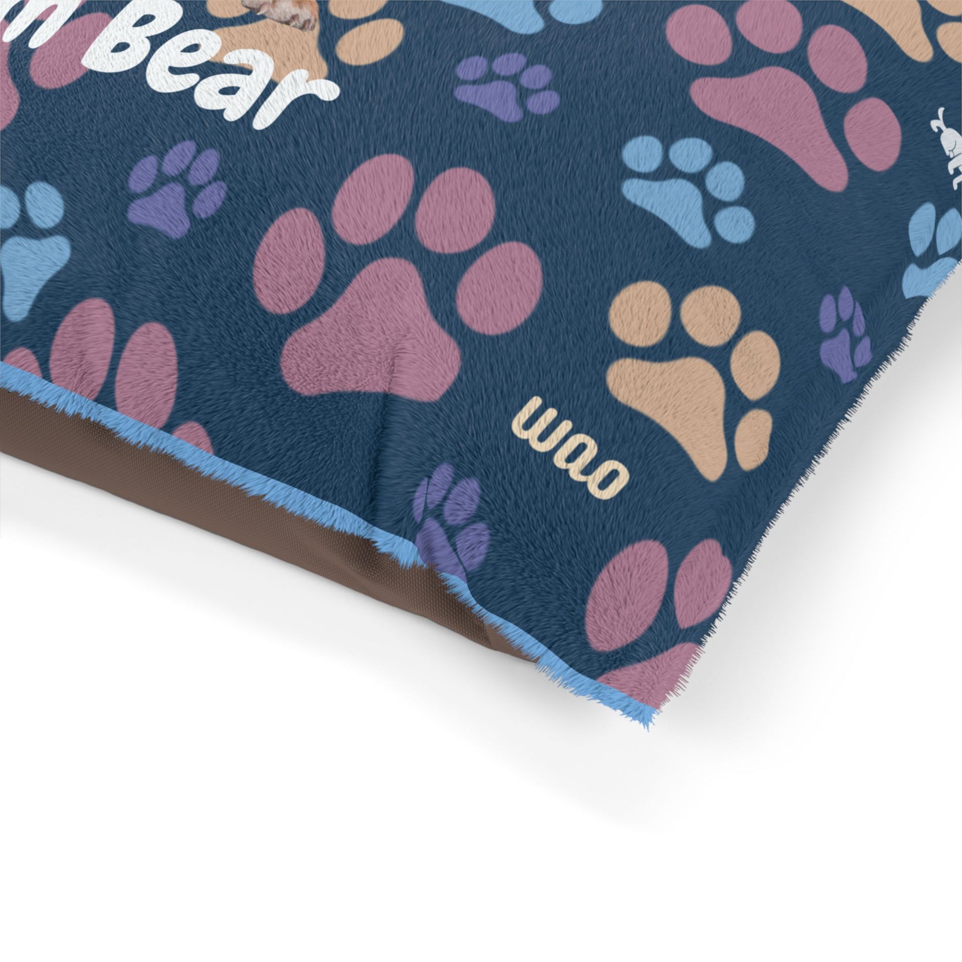 Dog mat with colorful paw prints and 'WAO' text on a blue background