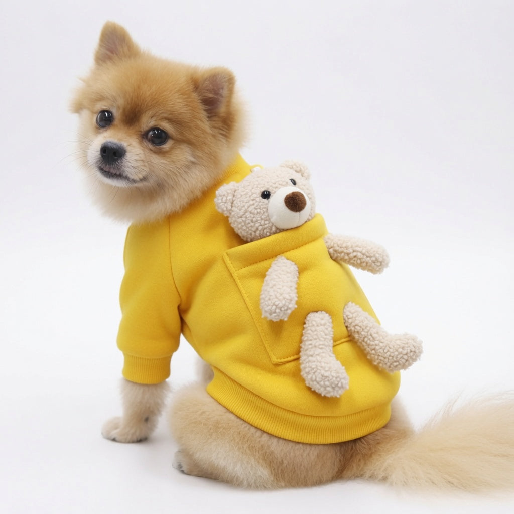 Small dog wearing a yellow Teddy Bear Dog Sweater with a teddy bear design on a white background