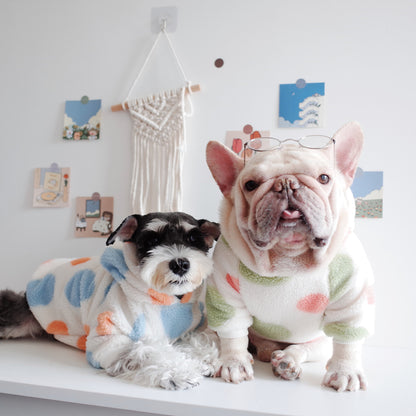 Two adorable dogs wearing cozy fleece hoodies with dot print design.